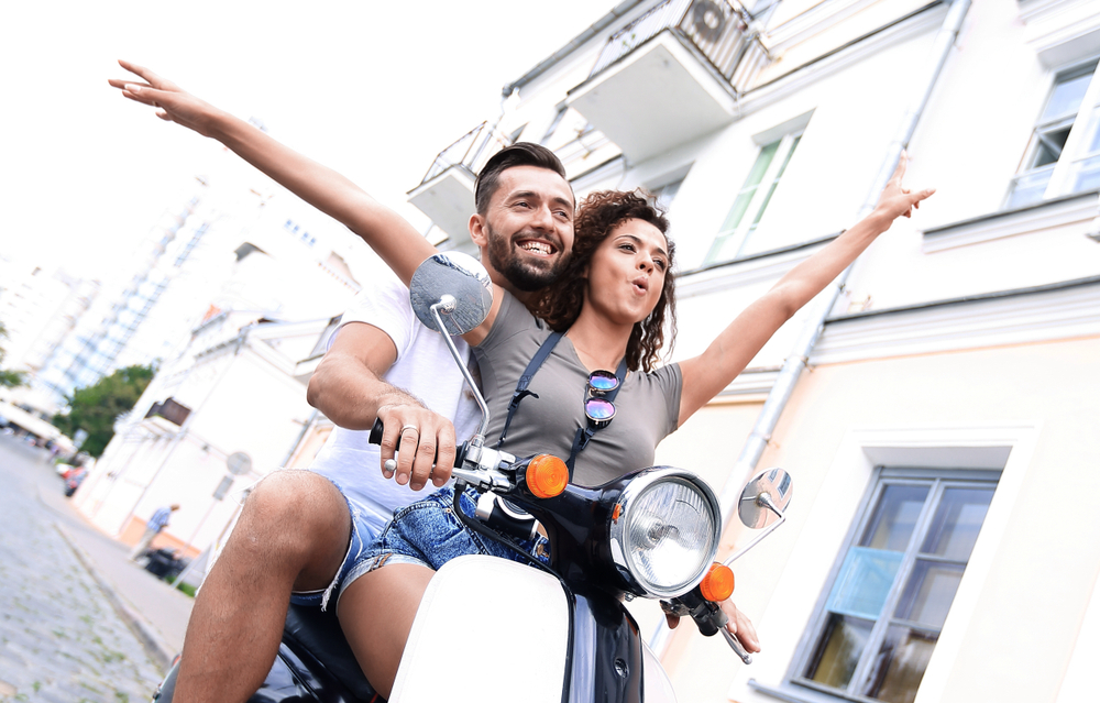happy man and woman on scooter